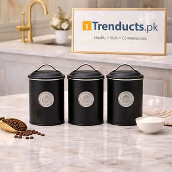 Metallic 3-piece storage jar set in black and white finishes, arranged neatly on a kitchen countertop.