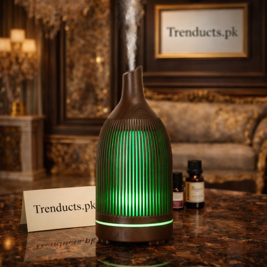 Light wood-grain teardrop aroma diffuser with soft purple LED light emitting mist on a marble tabletop.