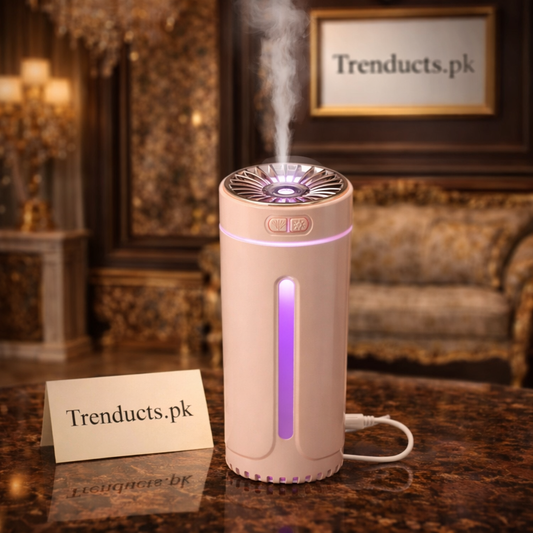 White portable USB humidifier emitting a fine mist next to a laptop on a modern desk with warm LED lighting.