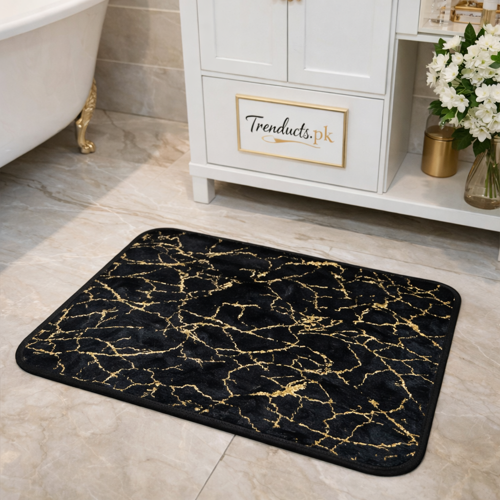 Black marble entryway mat with gold foil veins on a polished white floor in front of a dark wooden door.