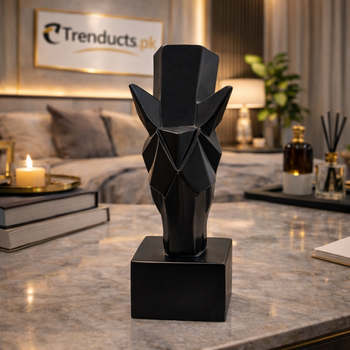 Matte black 25cm geometric horse head sculpture with sharp polygon facets on a glass desk in a modern office.