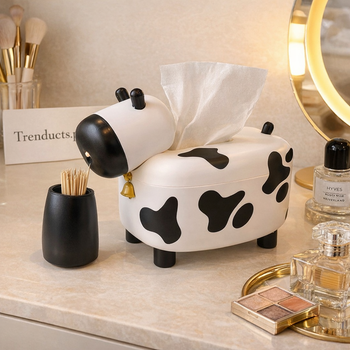 Soft pink cute tissue box holder with cat ear accents holding a smartphone in the front slot on a white desk.
