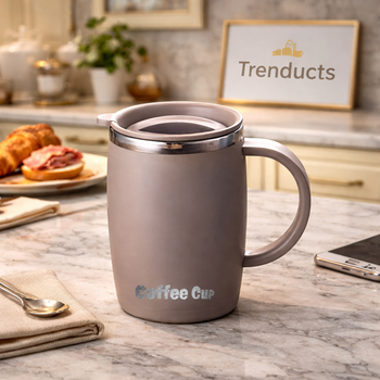 Minimalist cream-colored ceramic coffee mug with a unique bubble-shaped base and rounded handle, displayed in a trendy modern home office setting
