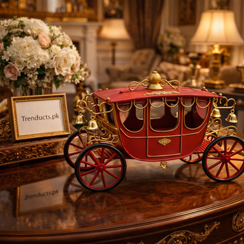 Ornate red and gold vintage carriage showpiece standing on a white marble console table in a luxury drawing room.