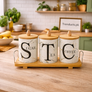 Matte black ceramic storage jar with a wood lid sitting in a light oak wooden stand on a modern kitchen counter.