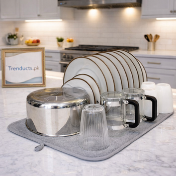 A slate grey microfiber dish drying mat with an integrated black plastic plate rack holding various kitchen utensils.