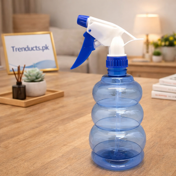 A chic, translucent water spray bottle with a spherical "bubble" base sitting on a minimalist wooden desk.