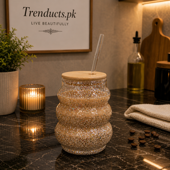 Three-tier ripple design double-walled glass mug with internal multi-colored glitter, a bamboo lid, and a clear glass straw.