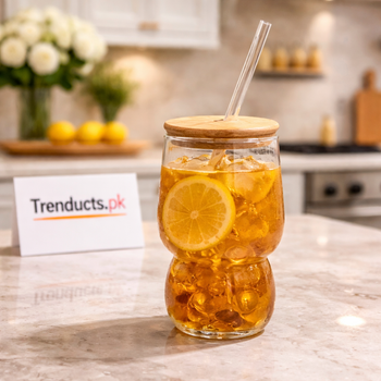 Aesthetic 550ml bubble-shaped iced tea glass with bamboo lid and glass straw containing iced tea and lemon on a kitchen counter - Trenducts.pk