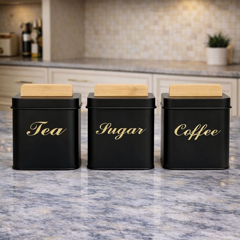 Three square matte black metal kitchen jars with light wood bamboo lids labeled Tea, Coffee, and Sugar - Trenducts Pakistan