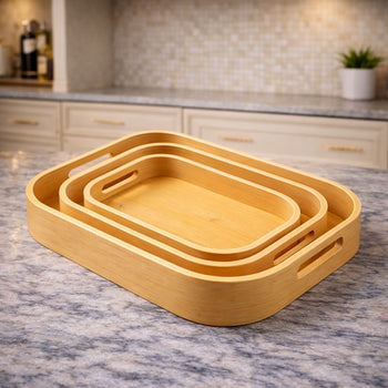 Three nesting square bamboo serving trays with integrated handles on a wooden dining table - Trenducts Pakistan
