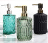Emerald green and sapphire blue ribbed glass soap dispensers with gold and silver pumps on a bathroom vanity - Trenducts Pakistan