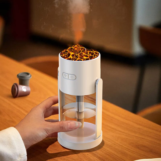 Black volcano-style aroma diffuser emitting orange flame-effect mist on a wooden bedside table.