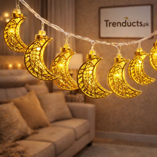 "Trenducts gold filigree crescent moon LED string lights with warm golden glow for Ramadan home decor."

"Close-up of metallic moon and star fairy lights for festive Islamic celebrations in Pakistan."