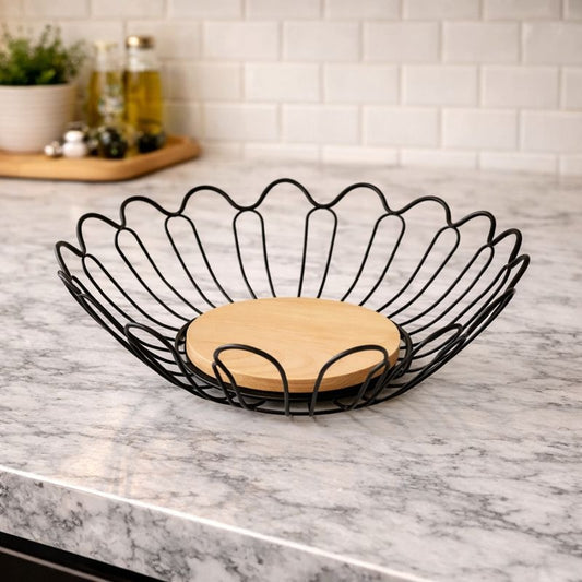 "Trenducts leaf-shaped matte black metal fruit basket with a solid oak wood base."

"Nature-inspired metallic leaf wire bowl for organic kitchen organization in Pakistan."