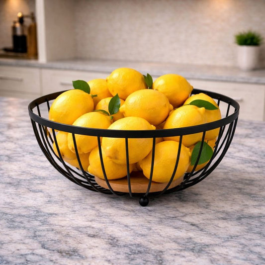 "Trenducts metallic wire fruit basket with solid oak wood base on a marble countertop."

"Minimalist matte black metal and wood fruit bowl for modern kitchen organization in Pakistan."