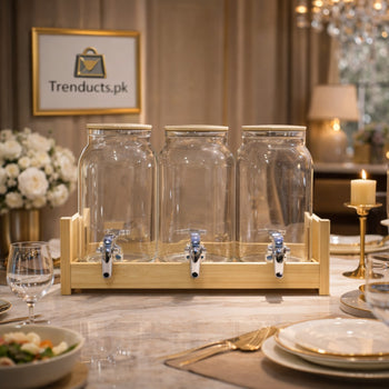 Three 2-liter glass juice dispensers with bamboo lids and stainless steel taps sitting in a tiered bamboo wooden frame.