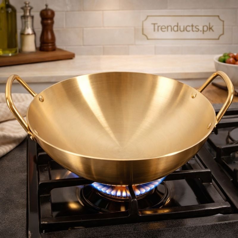 Stainless steel cooking pot karahi with golden finish on gas stove