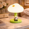 A glowing cloud-shaped nursery lamp with a cute panda character sitting at the base on a bedside table.