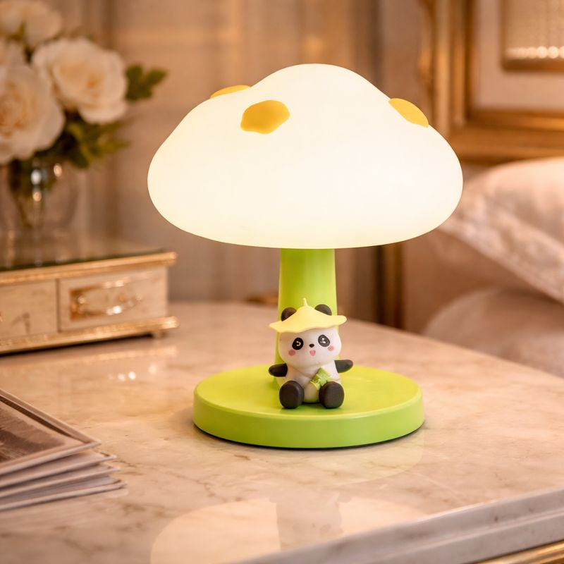 A glowing cloud-shaped nursery lamp with a cute panda character sitting at the base on a bedside table.