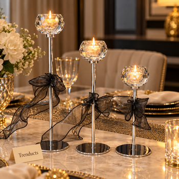 Candle stand set with black bows and round cups with lit candles on a dinner table - Trenducts