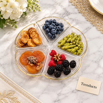 Glass plate filled with dry fruits and fruit on a dining table | Trenducts