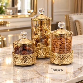 Gold canister set holding sweets and dry fruit on a dining table | Trenducts