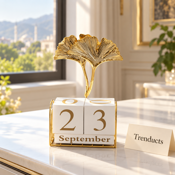 Gold desk calendar stand with ginkgo leaves on a study table | Trenducts