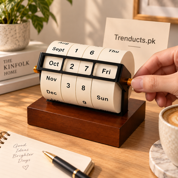 Hand adjusting the amber knob on a rotating wheel perpetual desk calendar