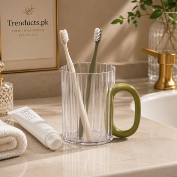 Transparent bathroom cup used as a toothbrush holder with Trenducts.pk branding
